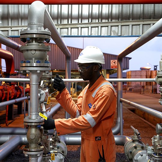 Worker in safety clothing and hard hat working on a pipe